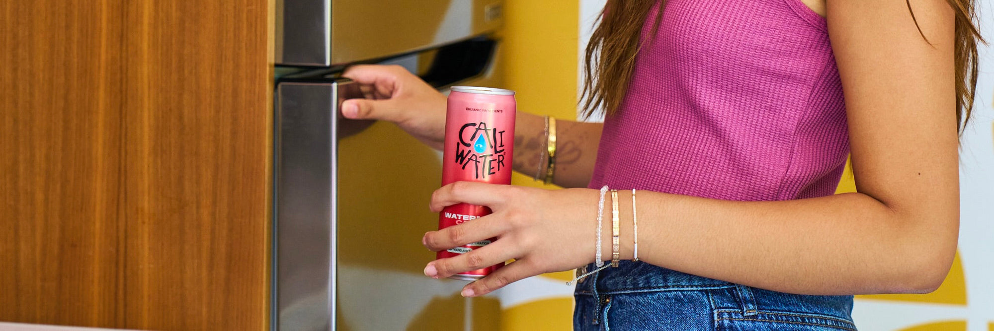 Woman grabbing a can of Caliwater Cactus Water from the fridge